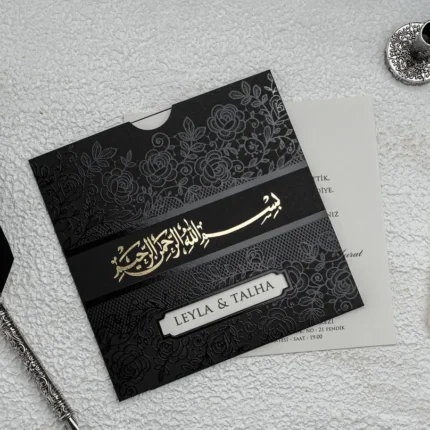 Invitație de nuntă neagră cu model floral embosat și scris auriu – design elegant premium