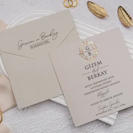 Invitație de nuntă crem cu coroniță florală și monogramă – design elegant romantic premium